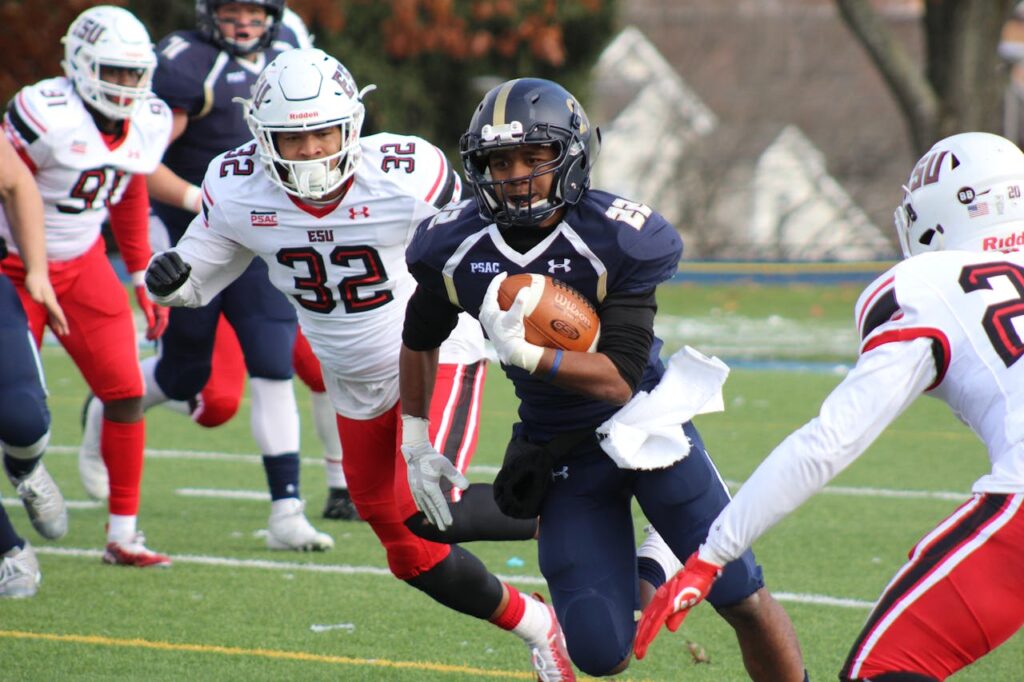 Football Player Carrying Brown Football